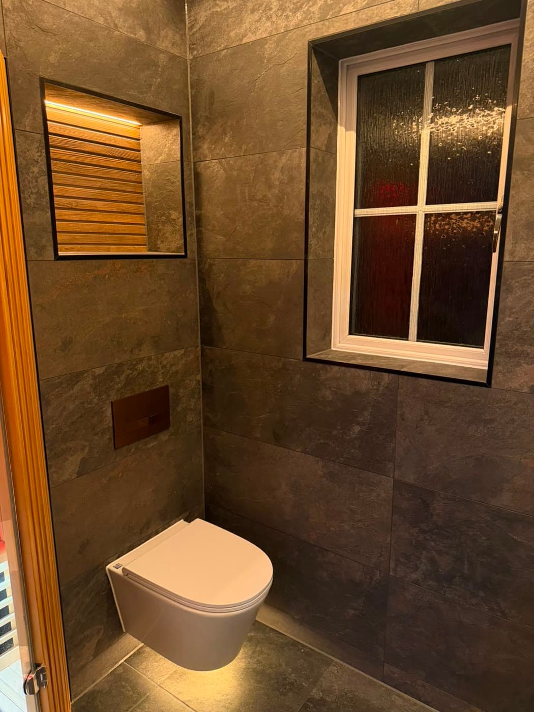 Slate tiled bathroom with a sauna cabin and slatted timber panelling, fitted by Caro Bathrooms