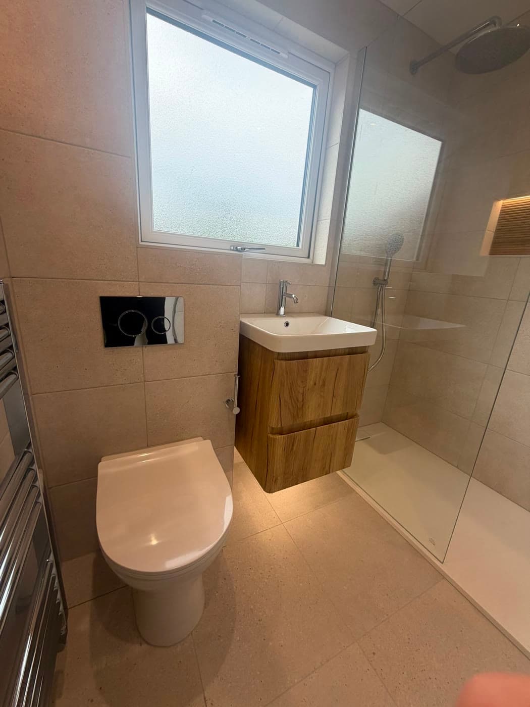 Bathroom with a wall-hung vanity, walk-in shower and a backlit niche, fitted by Caro Bathrooms